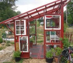 a small red and white house sitting in the middle of a yard