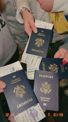 four people are holding up their passport cards