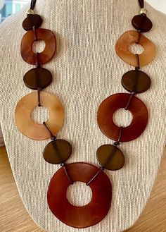 A neutral showstopper! This 28 inch long geometric, abstract statement necklace of beige, chocolate and dark brown circles is a hit for the Fall 2023 season. It's knotted in the cord in two or three places. A necklace that's as much art piece as jewelry.  Perfect for neutral outfits of cream, beige, khaki, white or black.  We want you to look beautiful, but keep your savings account, too: Our U.S. FREE SHIPPING guarantees your jewelry budget isn't eaten up by postage. Perfect gift.  Size: 28 inc Taylor Tomasi, Taylor Tomasi Hill, Eva Chen, Neutral Outfits, Modern Necklace, Island City, Fashion Institute, Necklace Chunky, Bib Necklaces