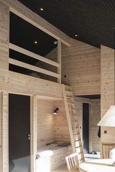 a room with wooden walls and stairs leading up to the upper floor, along with a table and chairs