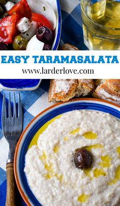 a bowl of oatmeal with olives and bread on the side next to a glass of water