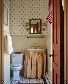 a bathroom with a toilet, sink and mirror in it's doorway view from outside