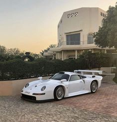 a white sports car parked in front of a building