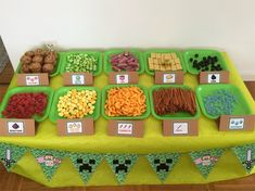 a green table topped with lots of different types of snacks and treats on top of it