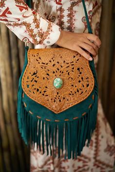 Discover the perfect blend of bohemian style and artisanal craftsmanship with our Boho Chic Green Suede and Leather Fringe Bag. This unique handbag features an intricately tooled leather flap adorned with a stunning turquoise gemstone centerpiece, adding a touch of elegance and charm. The rich green suede body, combined with the brown leather flap, creates a striking, earthy aesthetic. The adjustable strap ensures a comfortable fit, making this handmade fringe bag versatile for any occasion. Pro Leather Fringe Bag, Estilo Hippy, Fringe Crossbody Bag, Hippy Chic, Boho Chic Style, Bohemian Bags, Bohemian Lifestyle, Boho Purses, Fringe Bags