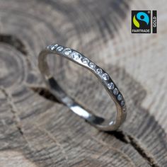 a close up of a silver ring on top of a piece of wood