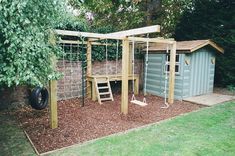 a wooden play structure in the middle of a yard