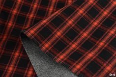 red and black checkered fabric with grey lining on the bottom half, close up