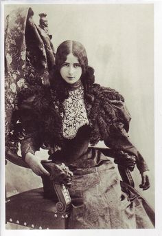 an old black and white photo of a woman holding a chair