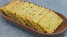 cheesy crackers in a wooden dish on a counter top, ready to be eaten