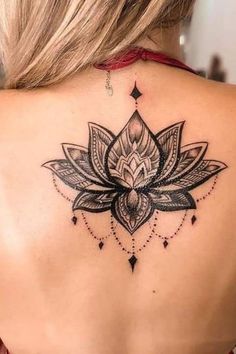 a woman's back with a lotus tattoo on it