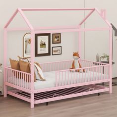 a pink toddler bed with a wooden frame and canopy