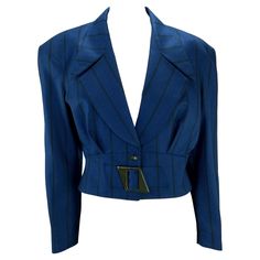 Presenting a blue cropped pinstripe Thierry Mugler blazer designed by Manfred Mugler. Since the 1980s, this blazer has been constructed of worsted wool and boasts a structural design and cinched waist for which Mugler is renowned. The jacket features large shoulder pads and a plunging neckline exaggerated by a belted waist. Approximate measurements: Size - FR40 Shoulder to hem: 19" Bust: 41" Waist: 29" Shoulder to cuff: 23" Underarm to cuff: 15.5" Peak lapel: 6" Leather-covered buckle: 2.5" X 3. Mugler Blazer, Structural Design, Blazer Designs, Peak Lapel, Thierry Mugler, The 1980s, Wool Blazer, Cinched Waist, Leather Cover