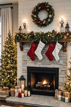 a fireplace decorated for christmas with stockings and candles