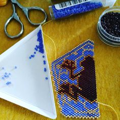 a pair of scissors, bead and beads on a table with other crafting supplies