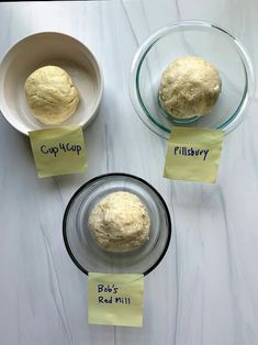 three different types of bread in bowls on a white counter top with sticky notes attached to them