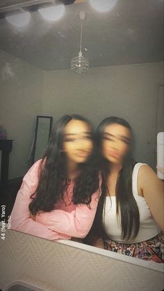 two women with their faces obscured by the mirror