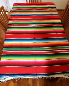 a colorful striped table cloth on a wooden dining room table