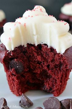 a red velvet cupcake with white frosting and chocolate chips