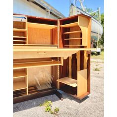 an open wooden cabinet sitting on the ground