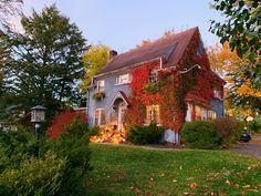 an old house with ivy growing on it's side and trees in the foreground