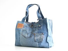 a denim bag with an orange tag on the front pocket and two zippered pockets