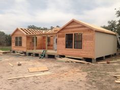 a house being built in the middle of a field with wooden boards on the ground