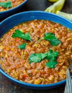 a blue bowl filled with beans and garnished with cilantro on top