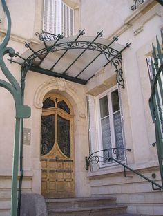 the entrance to an old building with wrought iron railings