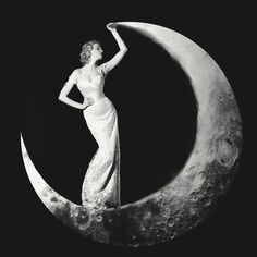 a woman standing on the moon with her hand in her hair