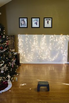 a living room decorated for christmas with lights on the wall and a dog bed underneath