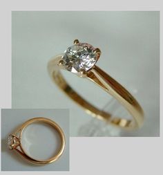 an engagement ring with a diamond in the center and a gold band around it, on a white background