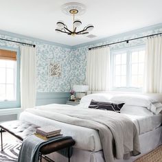 a bedroom with blue walls and white bedding