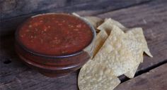 tortilla chips and salsa in a bowl on a wooden table