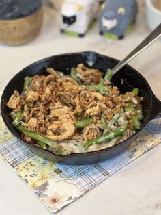 a skillet filled with food sitting on top of a table next to a napkin