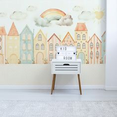 a white dresser sitting in front of a wall with a rainbow painted on it's side