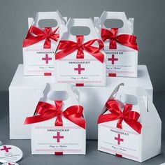 six white boxes with red ribbon and cross on them, all wrapped up in different designs