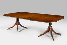 an antique dining table with two wooden pedestals