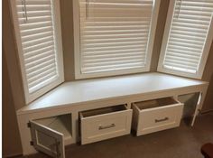 a window seat with drawers in front of it and shutters on the windowsill