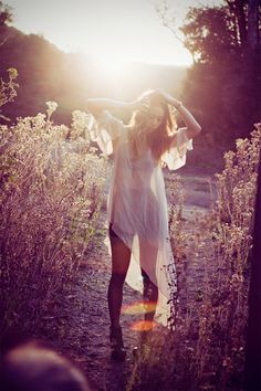 a woman standing in the middle of a field