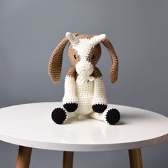 a crocheted stuffed animal sitting on top of a white table next to a gray wall