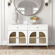 a white dresser with a mirror above it and vases on the top shelf in front of it