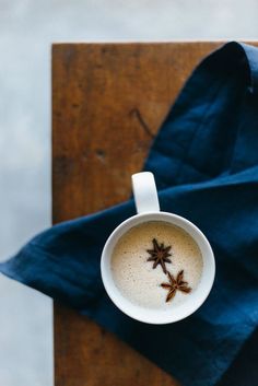 an overhead view of a cup of coffee with star anise on it