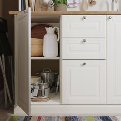 an open cabinet with pots and pans on it in a kitchen area next to a striped rug