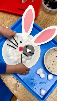 a child is making a paper plate bunny