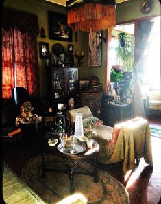 a living room filled with furniture next to a window covered in curtains and drapes