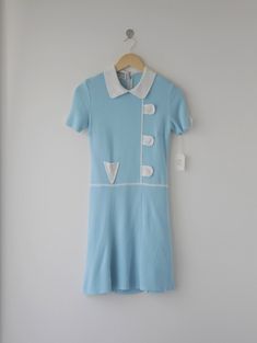 Très chic short-sleeve drop waist dress, from the 60s's Ye-Ye French pop style.  Peter Pan collar. The front and sleeves detail with cheerful decorative. Zipper on the back.  Colors: Azure blue, white  Size: 9 (Japan), fits like modern XS, S Fabrications: 60% acrylic, 40% rayon.  Maker: Renown Woman's young fashion Ye-Ye  Condition: excellent  Country of origin: Japan Retro Short Sleeve Dress With Buttons, Retro Short Sleeve Day Dress, Retro Short Sleeve Dress For Daywear, Fitted Short Sleeve 1950s Dress, Blue Retro Short Sleeve Dress, Blue Retro Dress With Short Sleeves, Retro Blue Dress With Short Sleeves, Fitted Short Sleeve Mini Dress For Daywear, Fitted Mini Length Short Sleeve Dress For Daywear