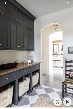 a large kitchen with black cabinets and white checkered flooring on the tile floors