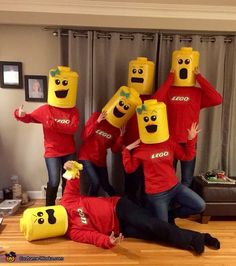 a group of people in red shirts with yellow faces on their heads posing for the camera