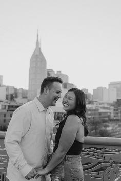 a man and woman standing next to each other in front of a cityscape